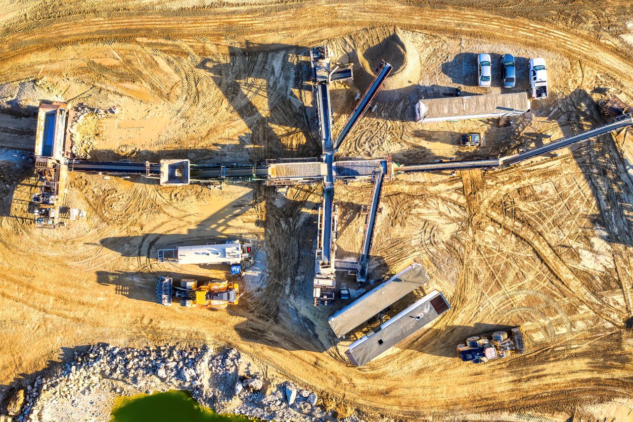 services-img Drone capture of an industrial mining site in Rochester, showcasing heavy machinery and equipment.