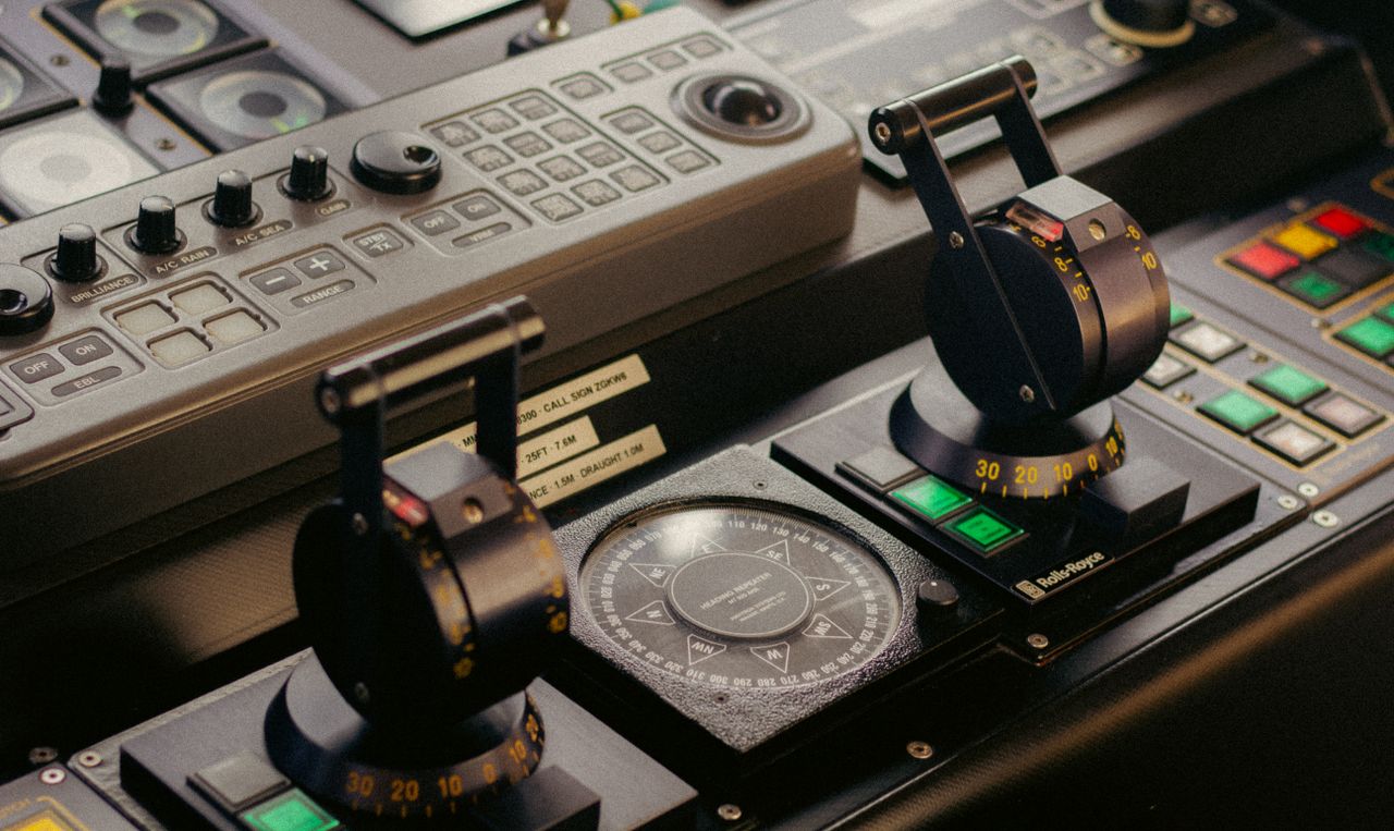services-01 Detailed view of a sophisticated control panel featuring levers, buttons, and compass.